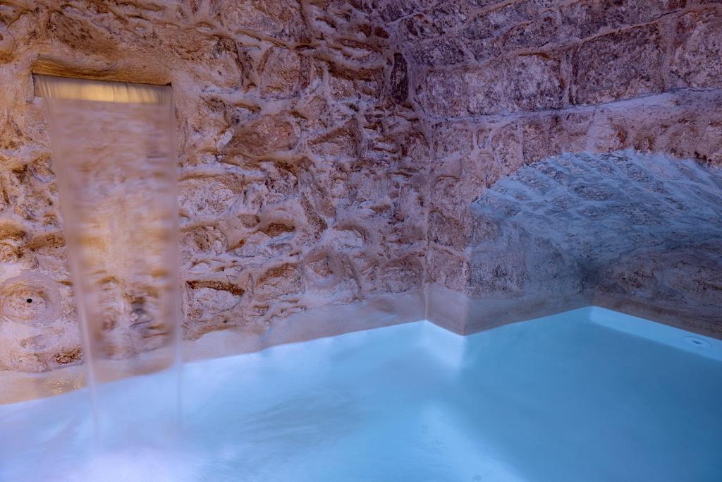 Zimmer mit einer Steinmauer und einem Fenster in der Unterkunft Suite Le Mele in Ostuni