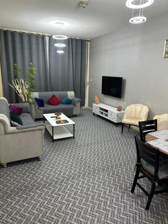 Apartment in Ajman في عجمان: غرفة معيشة مع أريكة وتلفزيون