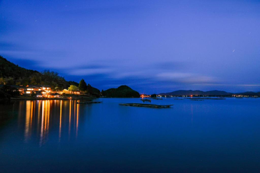 a view of a lake at night at 純和風旅亭 碧翠御苑 in Kyotango