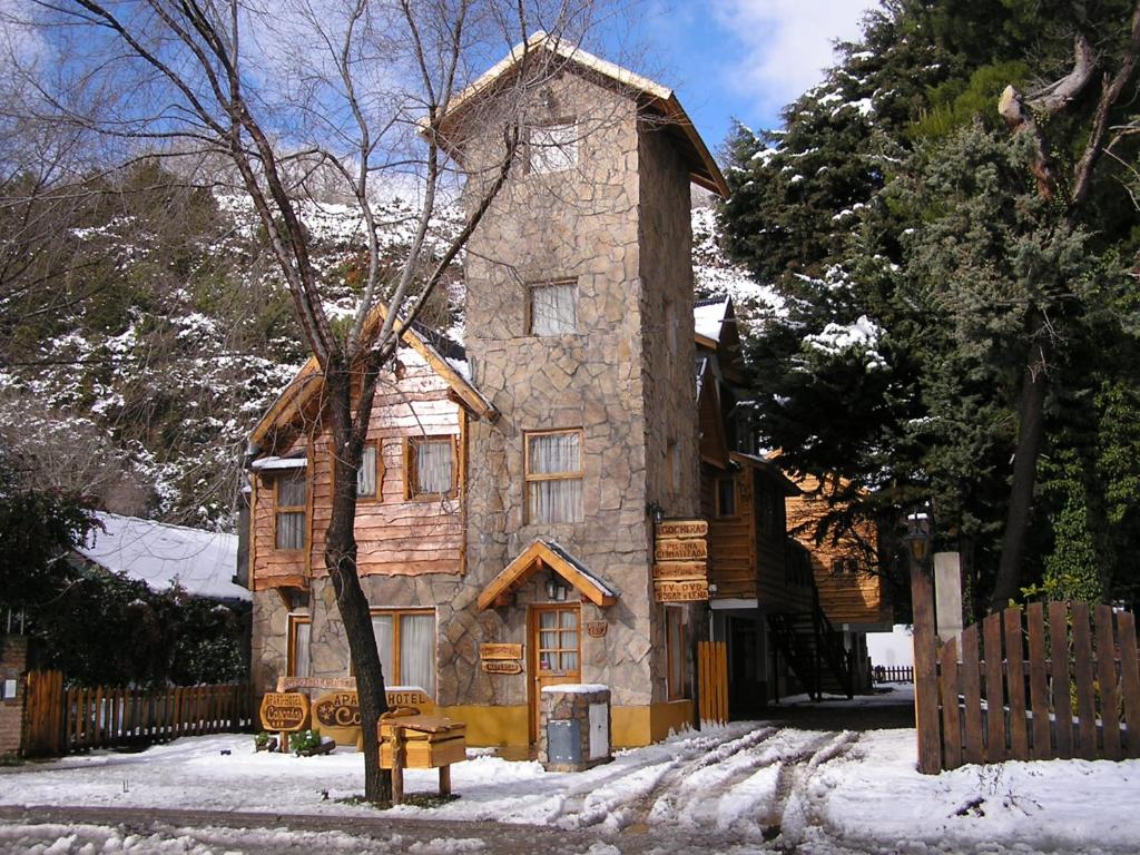 an old stone house with snow on the ground at Apart Cascadas in San Martín de los Andes