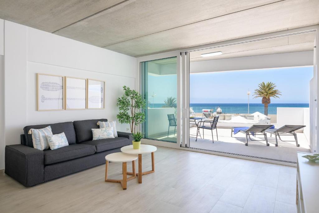 a living room with a couch and a view of the ocean at Playa de Guacimeta - Maresia in Playa Honda