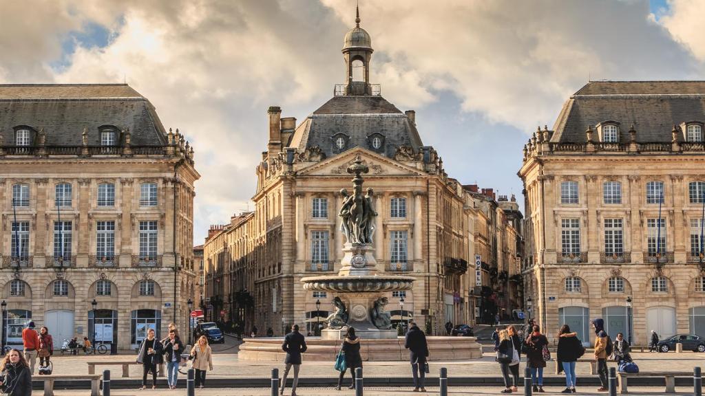 un groupe de personnes marchant devant un bâtiment dans l'établissement Nuit Insolite sur un Bateau au Cœur de Bordeaux, à Bordeaux