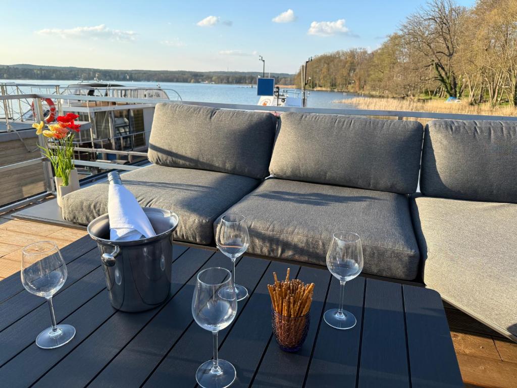 巴特萨罗皮斯库夫TraumZeitBoot Helmut auf dem Scharmützelsee Bad Saarow的一张桌子、酒杯和一张沙发