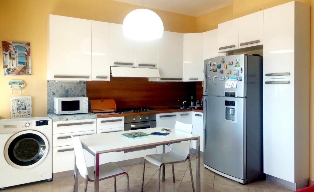 una cocina con una mesa y un refrigerador en Costa Degli Eucalipti, en Gaeta