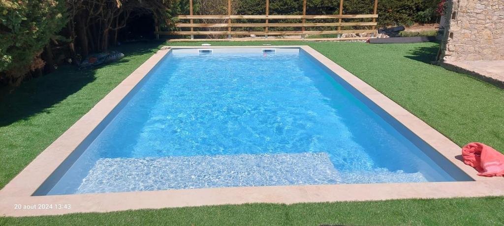 - une piscine dans une cour avec gazon dans l'établissement L'écureuil, à Martigues
