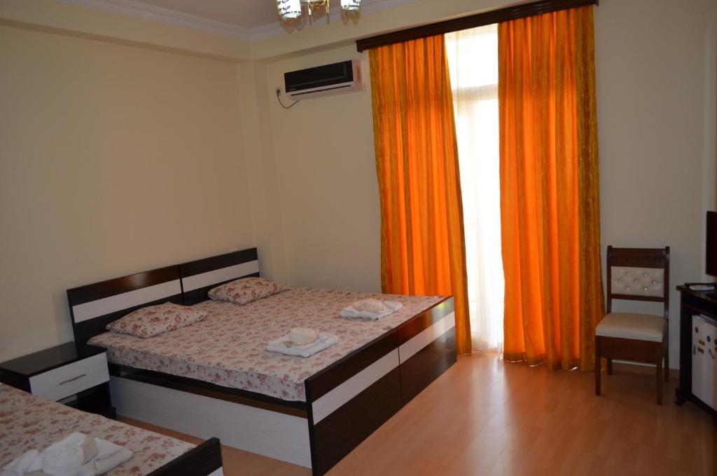 a bedroom with a bed and an orange curtain at Hotel Eurasia in Batumi