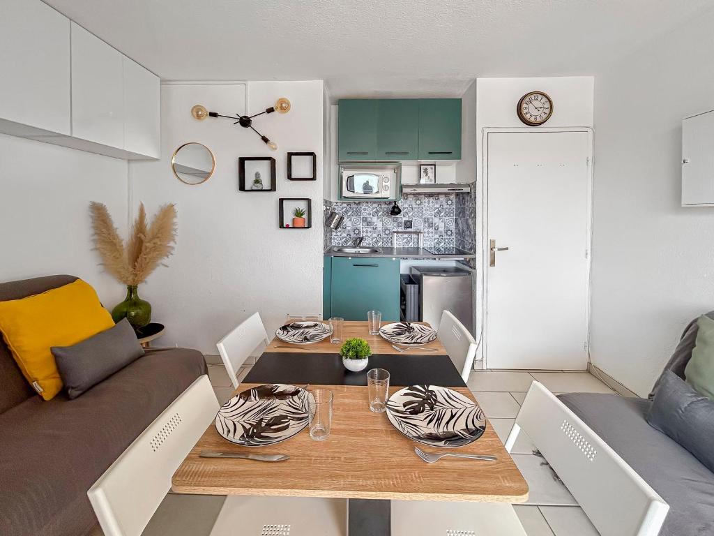una sala de estar con una mesa y un sofá en Studio cosy 4 pers à 150m de la plage !, en Le Barcarès