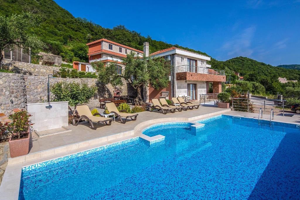 a swimming pool in front of a house at Villa Svinjista in Budva