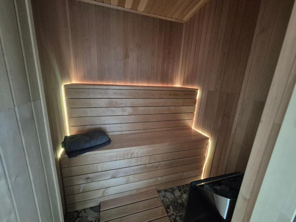 a sauna with a bench in the corner with lights at Charming Cottage - Sauna - Central Location in Šiauliai
