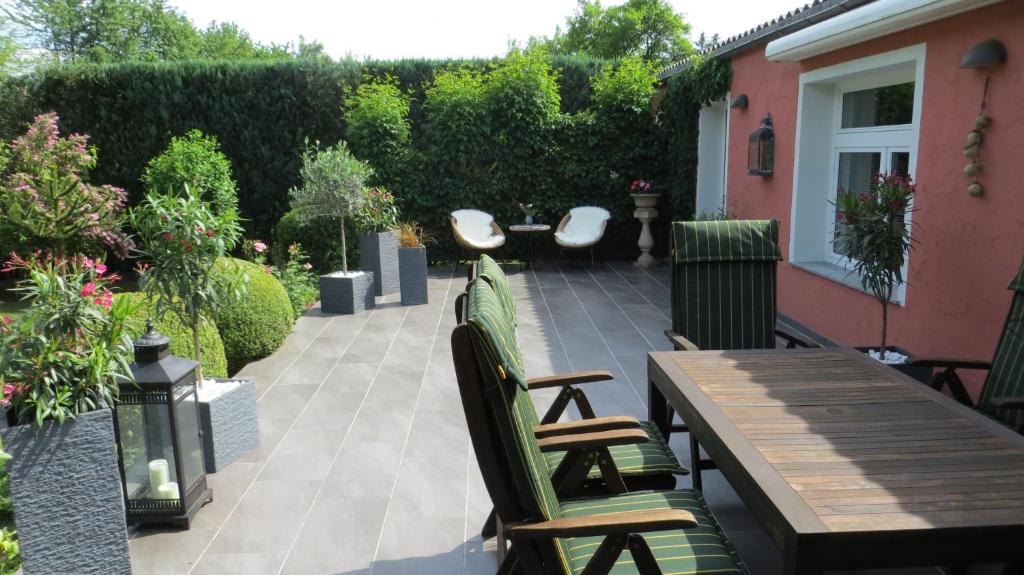 eine Terrasse mit einem Holztisch und Stühlen in der Unterkunft Ferienwohnung Dörner in Pirna