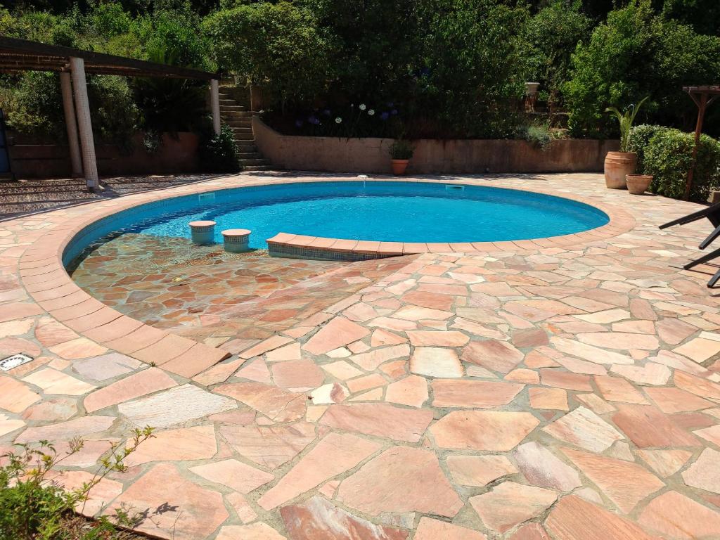 - une piscine dans une cour avec une terrasse en pierre dans l'établissement Maison presqu'île de Giens, à Hyères