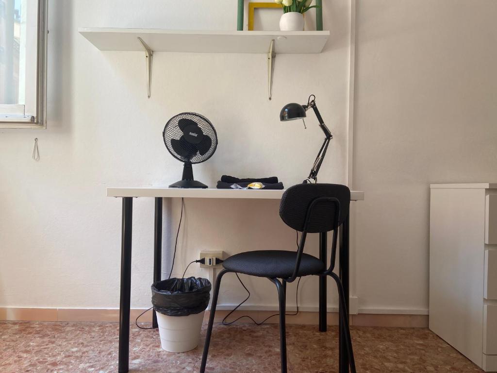 una scrivania con sedia nera e lampada di Casa Rella - Camera Green a Bologna
