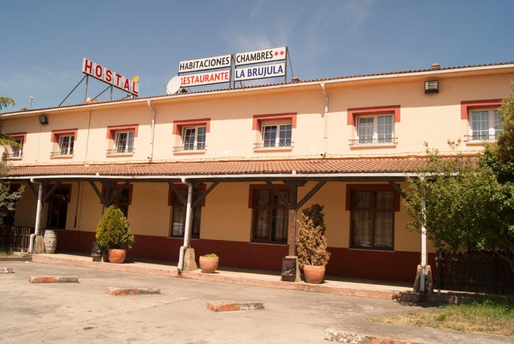 un viejo edificio con un cartel encima en Hostal Hermanos Gutierrez, en Monasterio de Rodilla