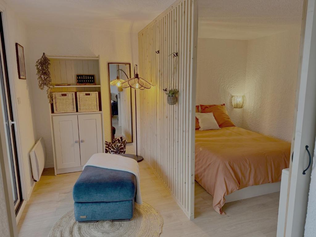 1 dormitorio con 1 cama y 1 reposapiés azul en Les Duc(s) de l'Airelle, en Les Carroz d'Araches