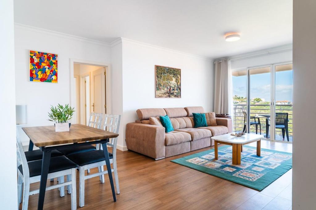 a living room with a couch and a table at GuestReady - Caniço city view in Caniço