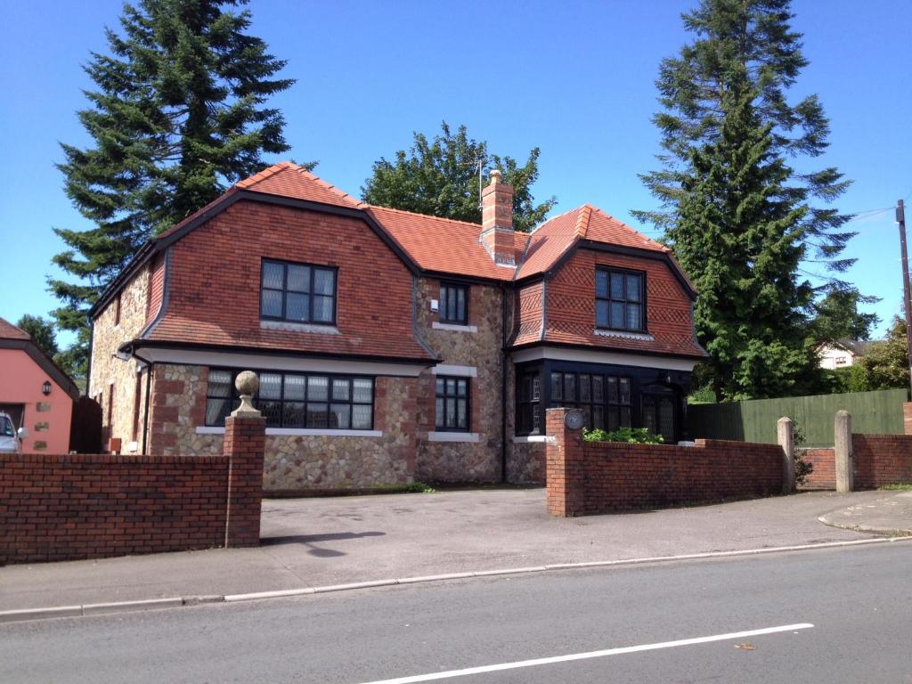 uma casa de tijolos com um telhado vermelho numa rua em Ty Mynydd Lodge em Cardiff
