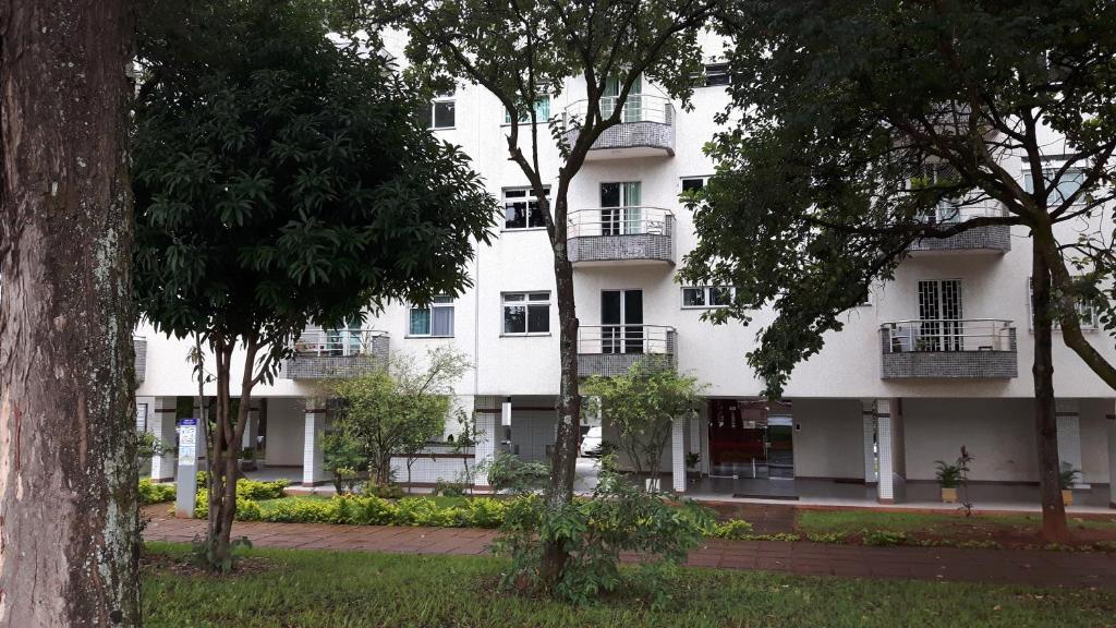 a white building with balconies and trees at Balkony 407 - Três quartos Perto UNB in Brasilia