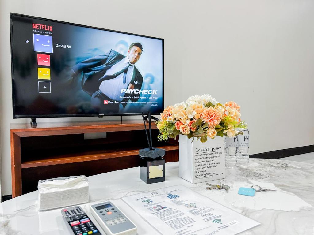 a table with a television and a remote control at Modern 1BR w Exclusive Pool Access in Lapu Lapu City