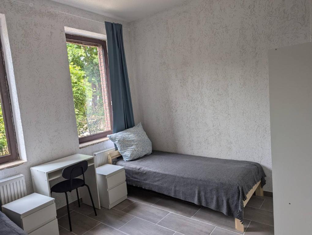 Un dormitorio pequeño con una cama y un escritorio. en Ferienwohnung Coppenbrügge, en Coppenbrügge