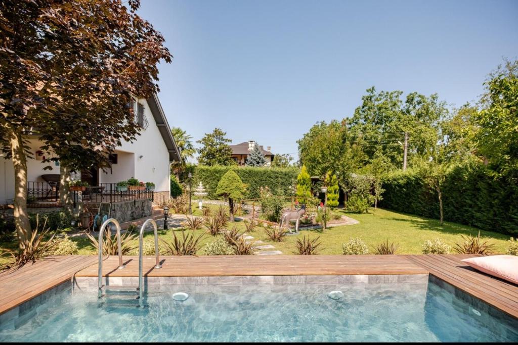 a swimming pool with a wooden deck and a yard at Villa Base Kırkpınar Detached Villa with pool in Sapanca