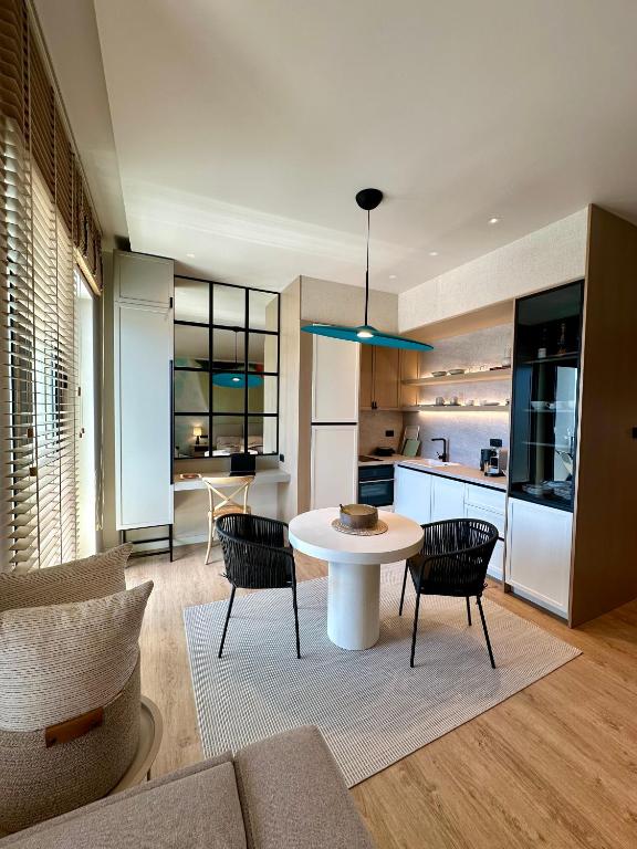 a living room with a table and chairs and a kitchen at Boka Place Home Thea in Tivat