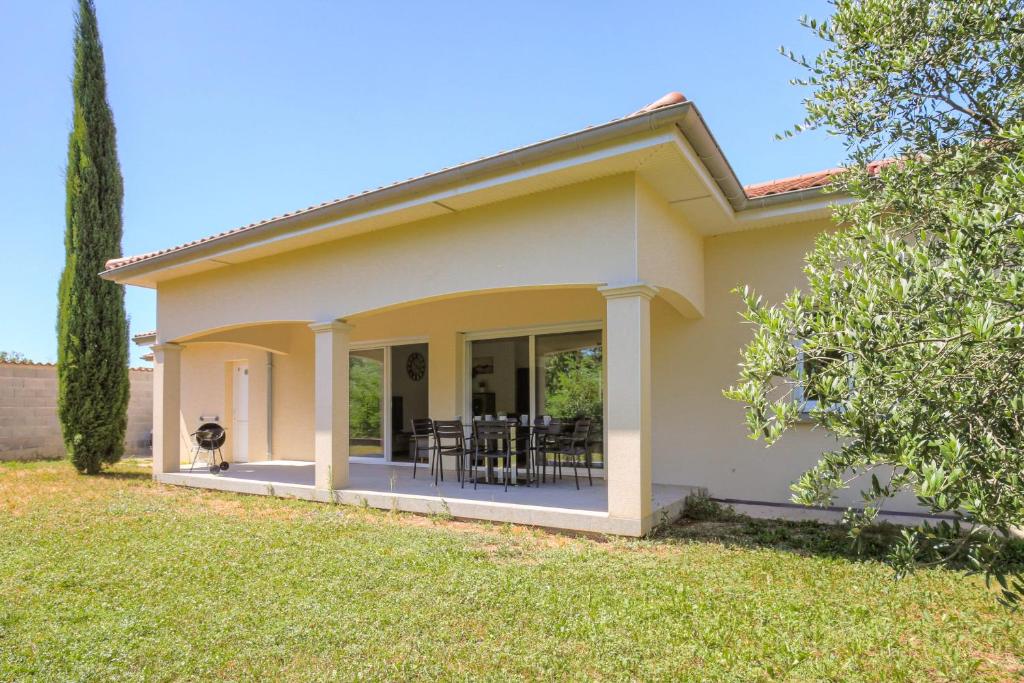 a home with a patio and a yard at Charmante maison 6 à 8 pers PMR proche Lyon in Seyssuel