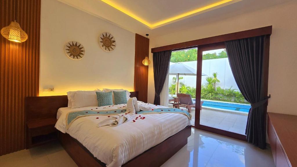 a bedroom with a bed with a view of a pool at Villa Serenity in Lovina