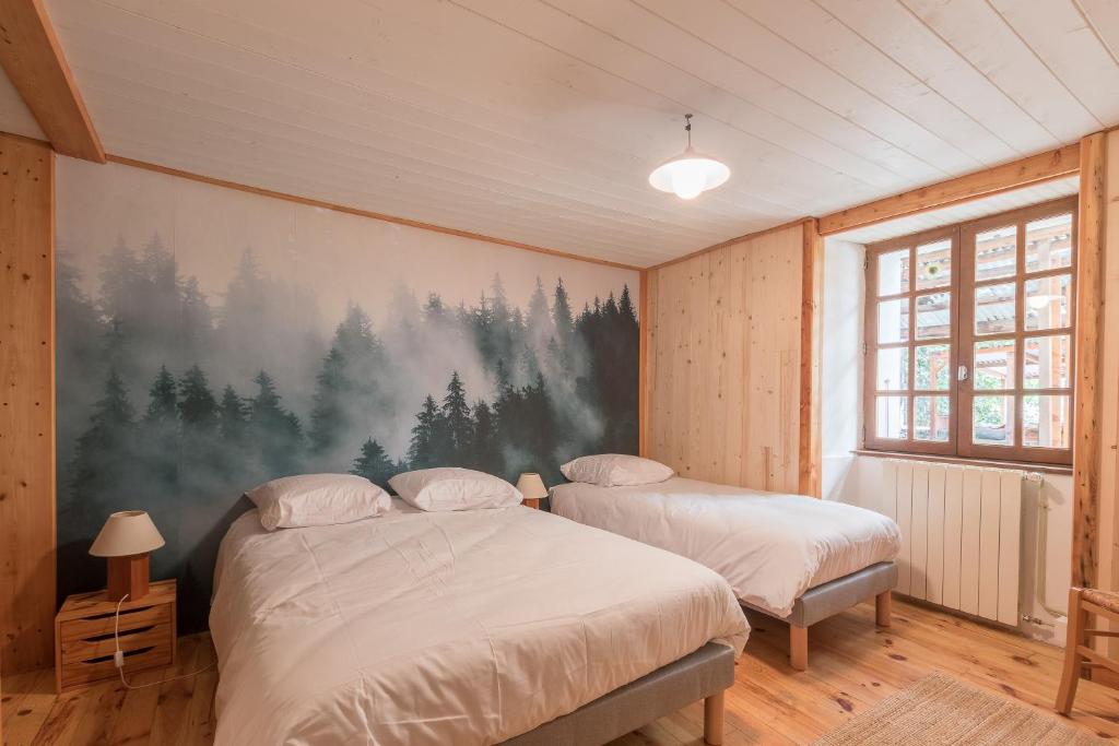a bedroom with two beds and a painting on the wall at La Petite Serenne - Vue Montagne 