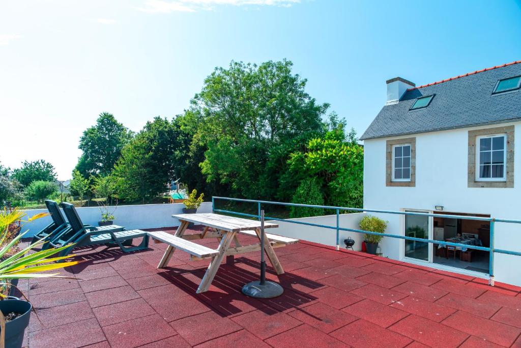 a patio with a table and two chairs on a roof at Ty Penn Ar Bed - Proche de la Plage in Plomodiern