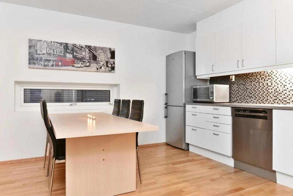 a kitchen with a table and chairs and a refrigerator at Modern & cozy 4BR apartment in Oslo in Oslo