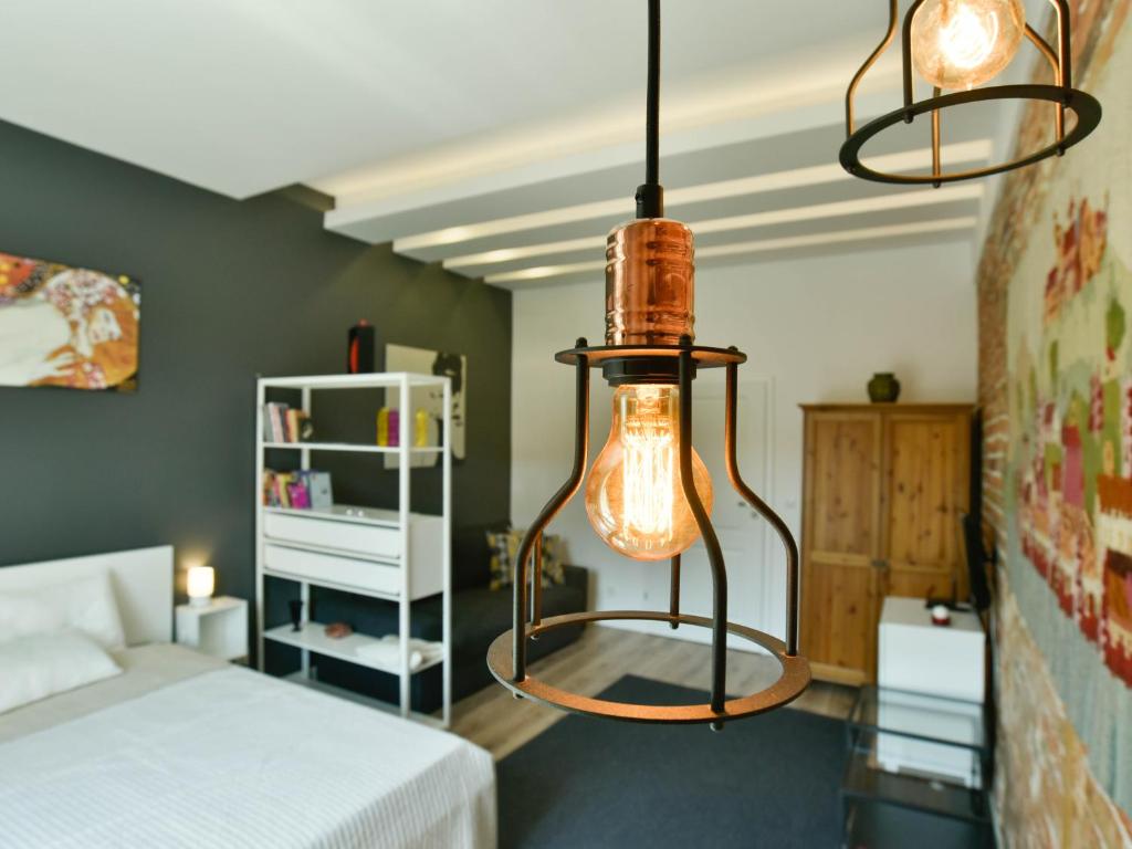 sypialnia z łóżkiem i 2 wiszącymi lampkami w obiekcie K12 Apartments w Krakowie
