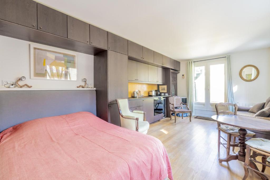 une chambre avec un lit et une table et une cuisine dans l'établissement Coeur de Versailles - Vue jardin apaisante & calme, à Versailles