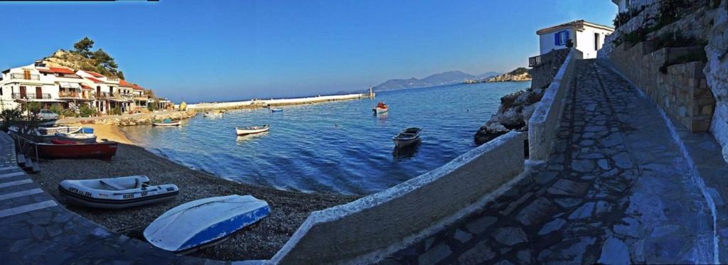 a group of boats in the water next to a wall at Kate Apartments in Kokkari