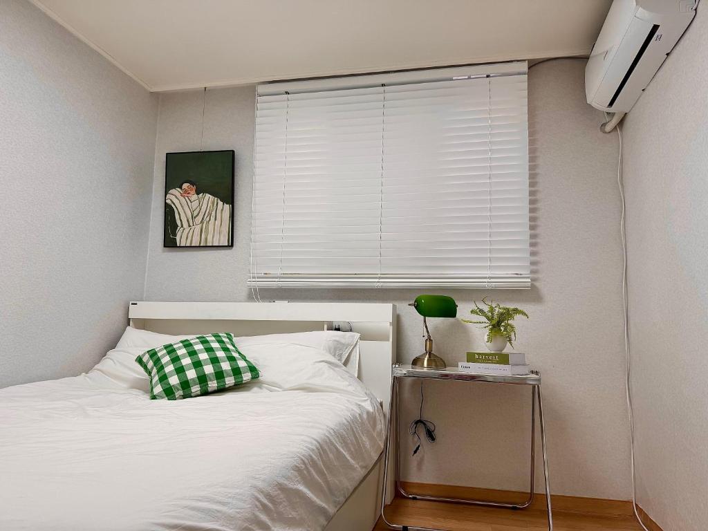 a bedroom with a white bed and a window at Hi Seoul Daechi in Seoul