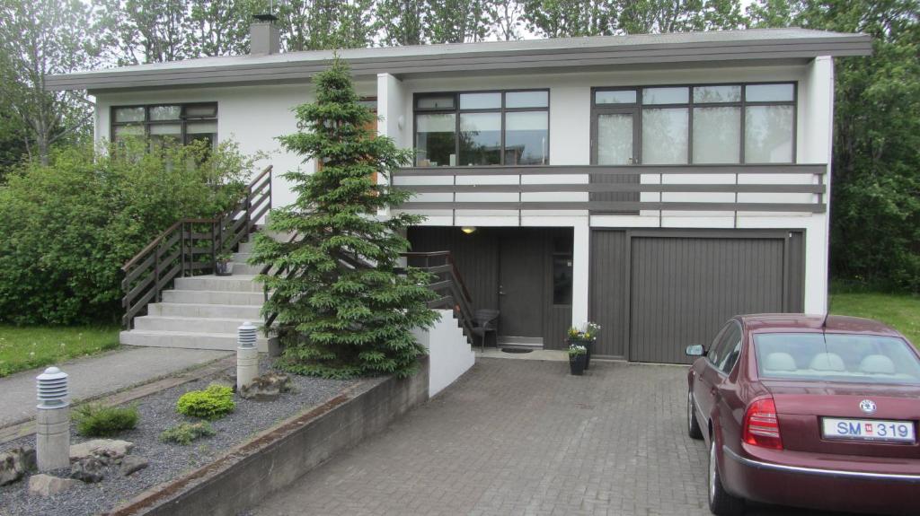 a house with a red car parked in front of it at SKOLO Apartment in Selfoss