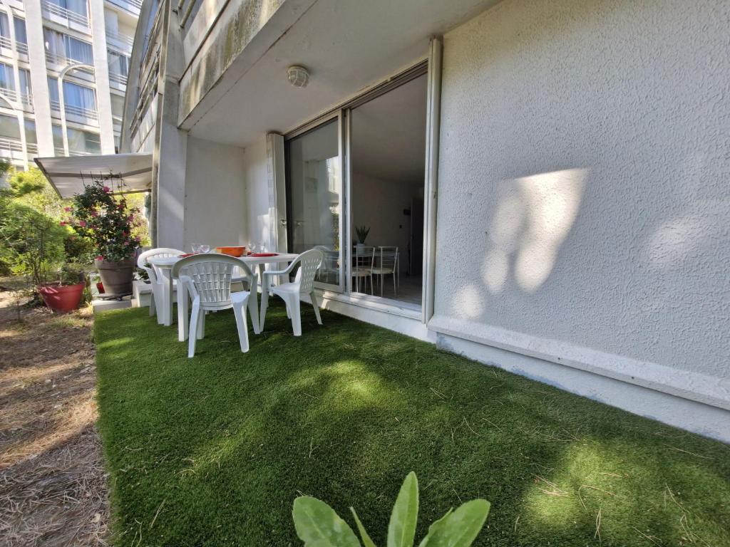 d'une terrasse avec une table et des chaises sur le côté du bâtiment. dans l'établissement Sol-y-Days jardins du couchant, à La Grande Motte