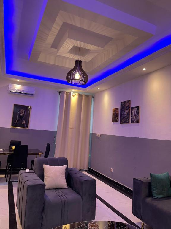 a living room with couches and a blue light at Maison Royale in Kofa