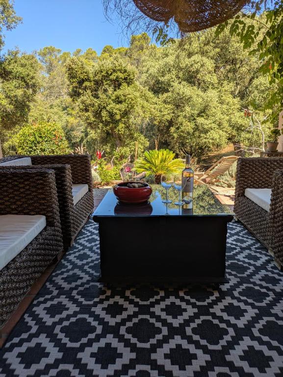 d'une terrasse avec une table et deux chaises en osier. dans l'établissement Villa Bleucassis, à Taradeau