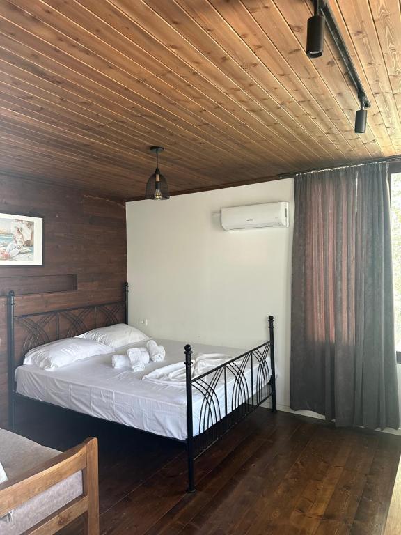 a bed in a room with a wooden ceiling at SEA bed and restaurant 2 in Borsh