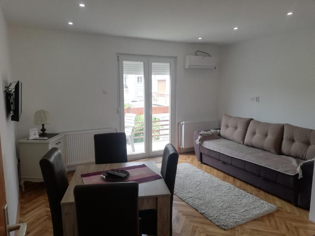 ein Wohnzimmer mit Couch und Tisch in der Unterkunft Apartmani Ana S in Vrnjačka Banja