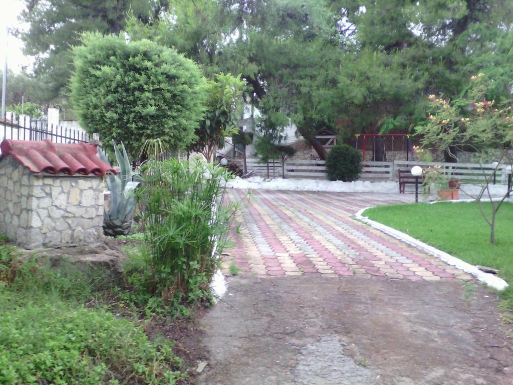 a brick walkway in a yard with a fence at Avra Ηouse in Kriopigi
