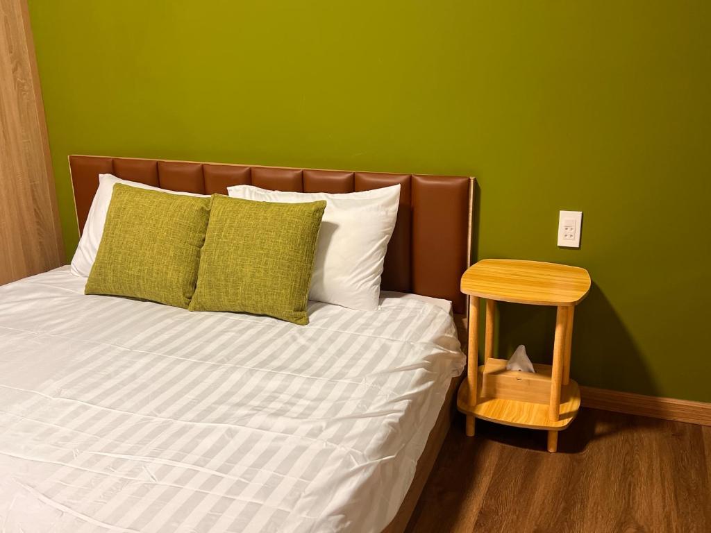 a bedroom with a bed with a green wall at VACANCE APARTMENTs in Ho Chi Minh City