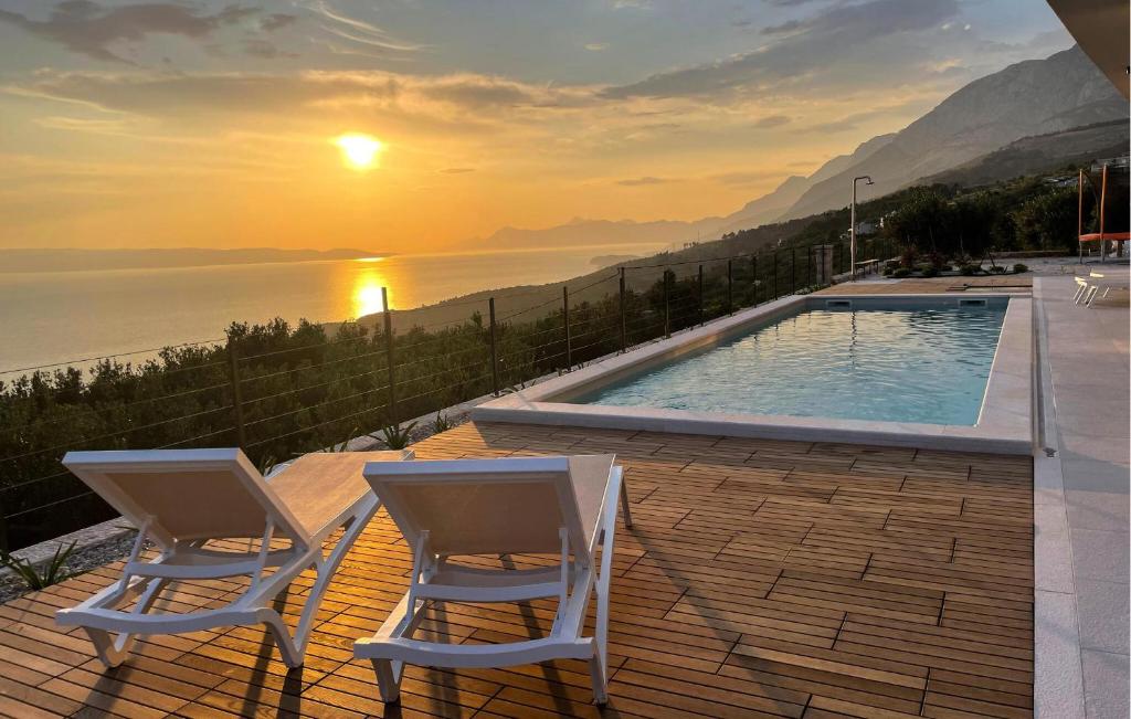a couple of chairs sitting next to a swimming pool at Amazing Home In Podgora in Podgora