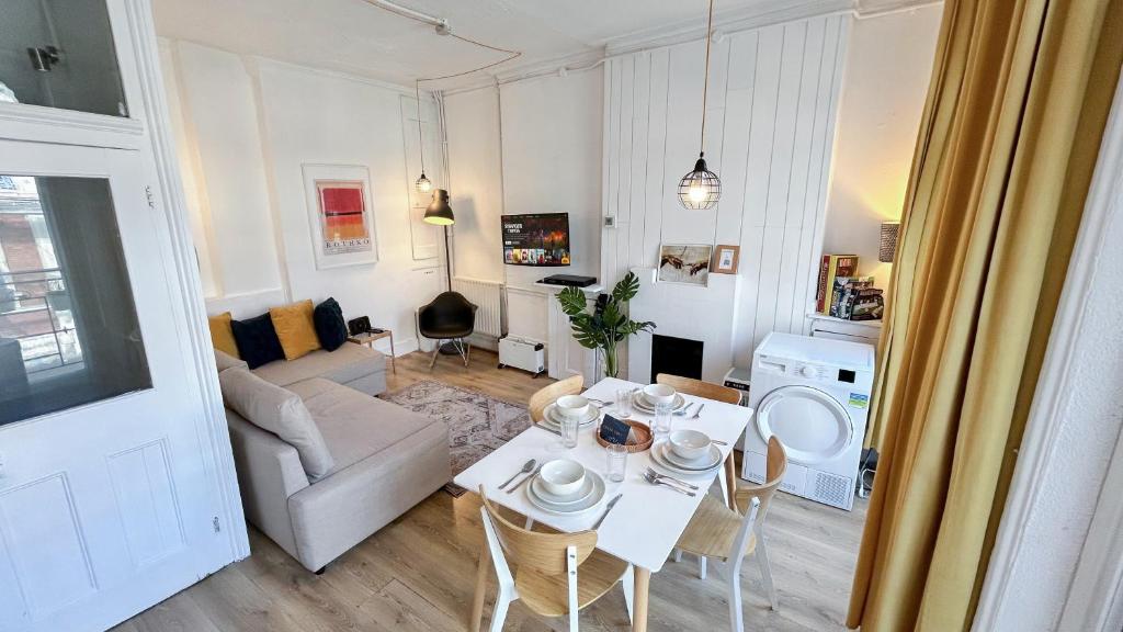 a living room with a table and a couch at Stylish 2-Bedroom Flat in Barbican Centre near Farringdon with Rooftop Terrace in London