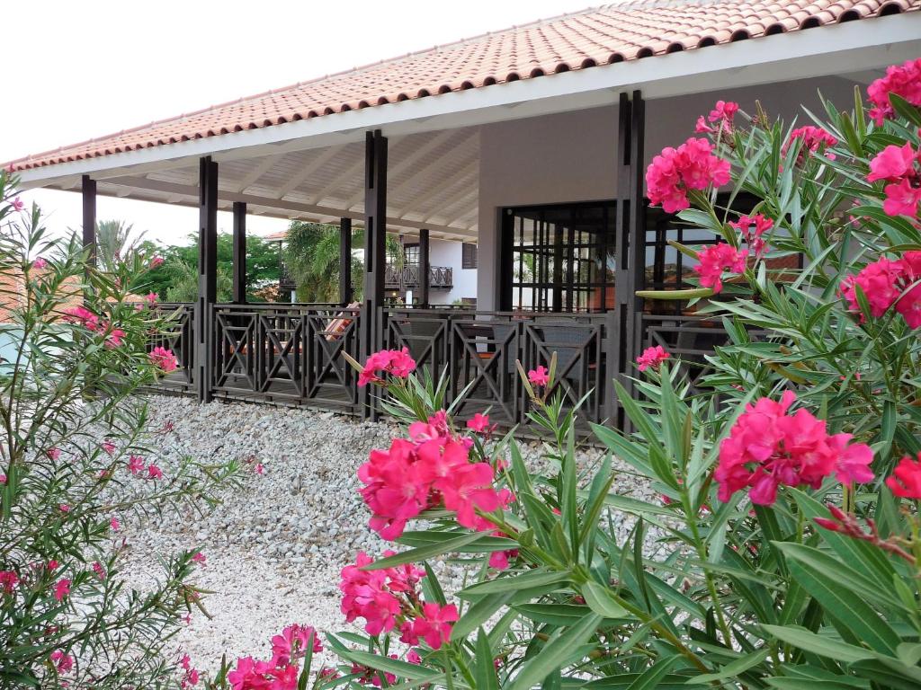 una casa con flores rosas delante de ella en Blue Bay Beach Villa 14, en Blue Bay