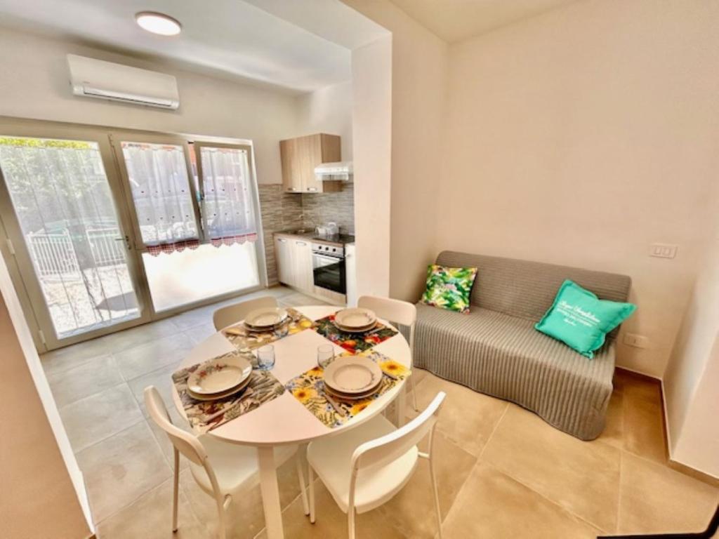 a dining room with a table and a couch at Mono Limone dx con corte, posto auto ed aria condizionata a due passi dal mare in Marcelli
