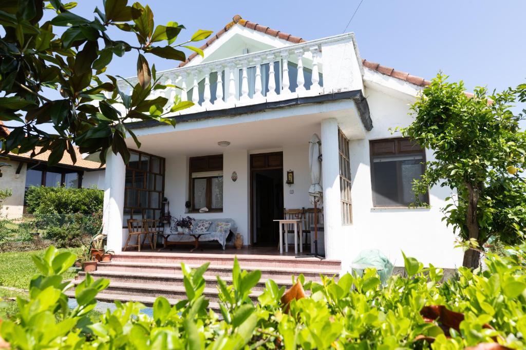 een wit huis met een veranda en een trap bij Casa Nina in Somo