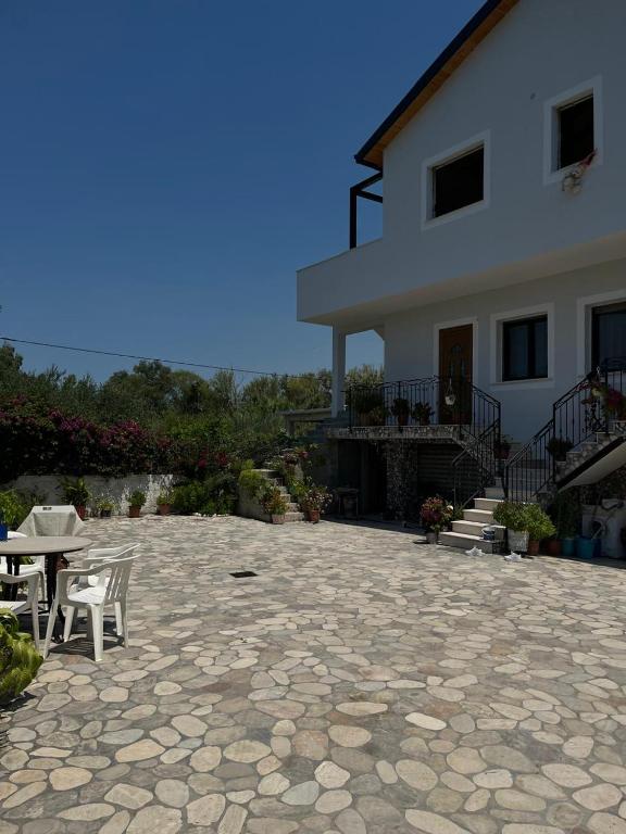 a house with a patio and a table and chairs at Holiday home in Vlorë