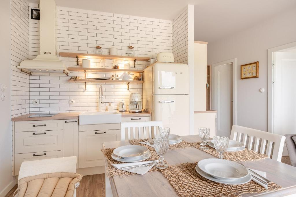 a kitchen with a table with plates on it at Sunset Resort VI, Nadmorska 98A in Grzybowo