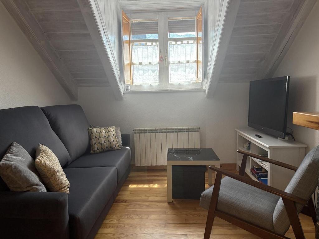 een woonkamer met een bank en een tv bij BPirineos-La Tea in Benasque